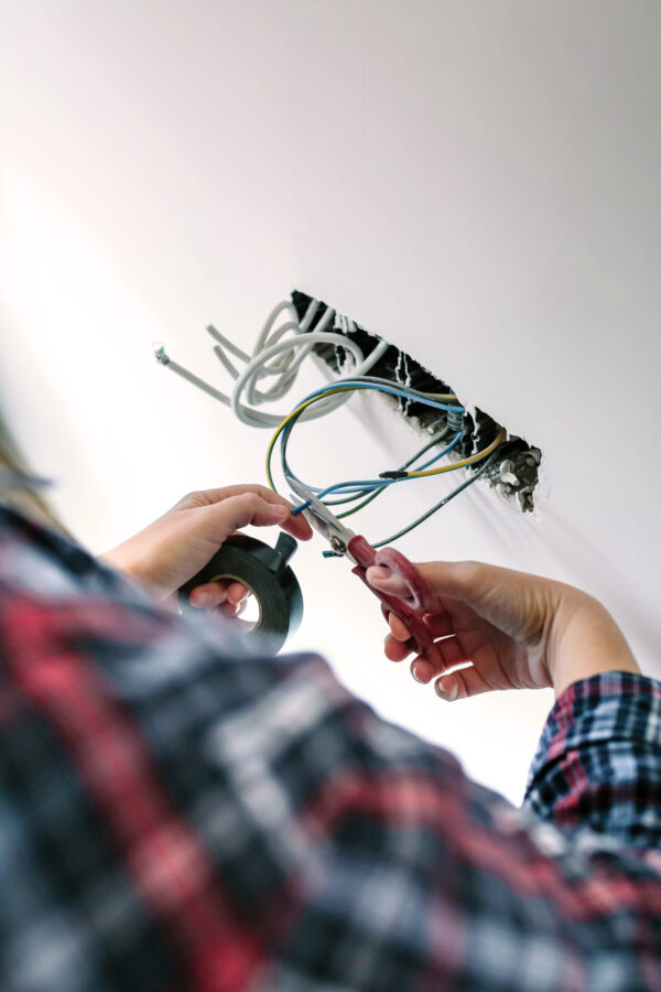 Unrecognizable electrician working on the electrical installation of a house Some Product